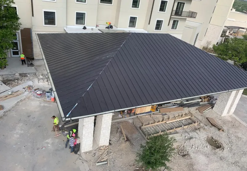 Metal roofing installation team working on a commercial building in Fenton